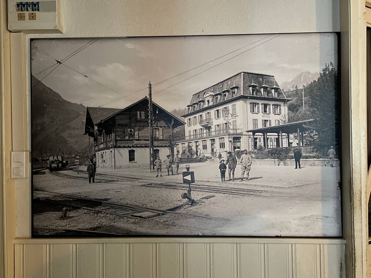 A black and white photograph on the wall of the hotel, of the hotel many years ago.