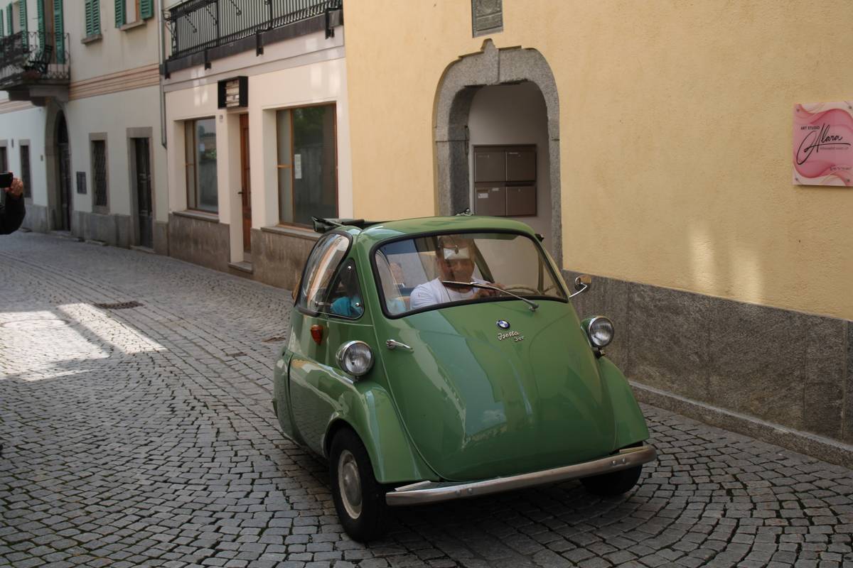 A green BMW Isetta on a stone paved street